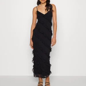 Volangklänning ginatricot - Superfin svart långklänning från Ginatricot i storlek S i nyskick med alla lappar kvar på. Slutsåld i butik och på hemsidan 