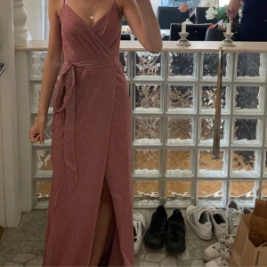 Balklänning - Jag säljer min rosa balklänning, den är använd endast en gång! Och den har inte skador eller liknande. Det är i storlek XS. Den är lite glittrig och det är en slits längst ner på ena benet❤️Nypris är 1099kr. Hör av er för fler bilder❤️