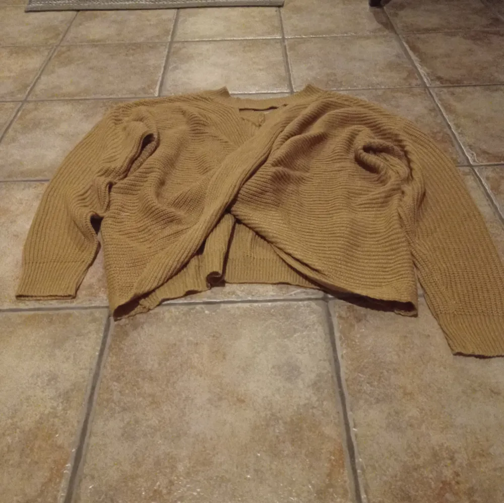 Nyinköpt samt oanvänd tröja. Baksidan är den korsad. Färg skulle jag säga aprikos/ kaki. På beskrivningen av tröjan står det aprikos.. Neuletakit & Villapaidat.