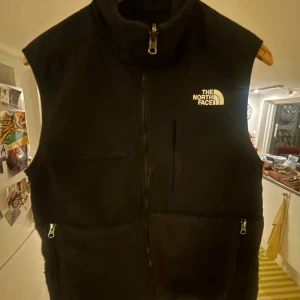 The North Face vest - En svart North Face vest som har 2 olika materialer på utsidan. Den är gjord med tjockt flismaterial och är mycket varm. Fickorna på brösten är feta, de blandar in bra med materialet på övre halvan av västen. Den är fet den här vesten. Skick 8.5/10