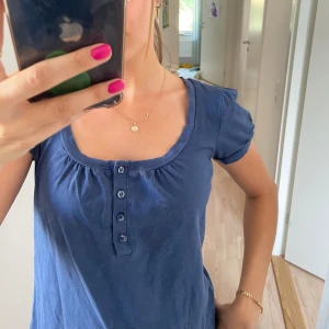 Blå topp - Super söt blå topp med knappar där fram! Passar stolek S-M beroende på hur du vill att den ska sitta