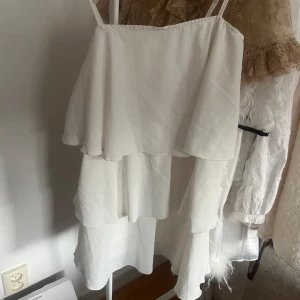 Vit klänning med volanger  - Superfin vit volangklänning köpt i spaninen, storlek xs/s med justerbara band ! Bra skick knappt använd🫶🏼