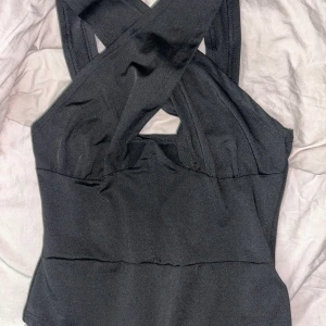 Body  - Säljer denna body med knäppning med band som korsas, helt oanvänd med prislapp kvar. Storlek M. 