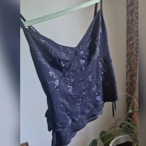 Kort Vintage topp - Säljer superfin vintage topp 💕♡Fina blommor detaljer  ♡Öppning med knytband i sidan ♡Perfekt till sommaren!