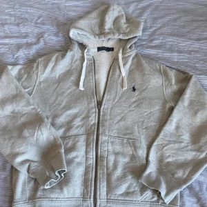 Ralph lauren zip  - Säljer nu denna gråa Ralph lauren zip hoodie.  Skick 8/10.  Säljer för den bara ligger och tar plats. Skriv vid frågor Pris kan diskuteras.