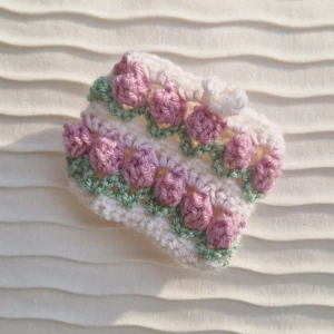 Tulpan accessoarhållare - Väskan/plånboken består av ett fint virkat tulpanmönster och en knapp man kan stänga den med. Passar perfekt för att hålla reda på accessoarer, kort, nycklar etc!