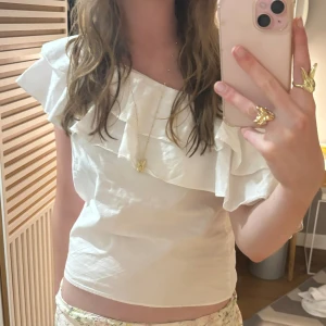 One shoulder topp m volang - Volangtopp! Kan bäras one shoulder eller off shoulder. Storlek S