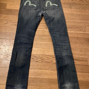 Evisu x Puma Jeans - Japanska märket Evisu Jeans sällsynt collab med Puma Ikoniska evisu designen på backfickorna En puma i metall som dragkedja Distressing och patchwork Bra skick W30/L34