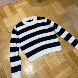 Stickad tröja  - Stickad tröja som är mörkblå och vit ser dock svart ut på bilden storlek l men liten i storleken sitter ungefär som en s 