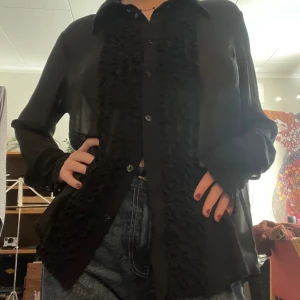 Skjorta med volanger - Svart chiffon skjorta med volanger från KappAhl!