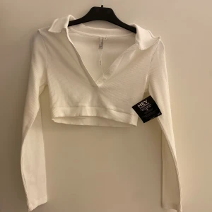 Vit långärmad topp, NELLY - Helt oanvänd långärmad croppad topp från Nelly.  Storlek S