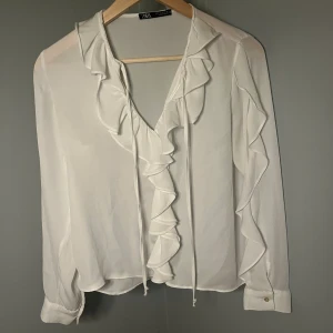 Vit volang blus  - Superfin vit blus från zara. Kommer inte till användning tyvärr men är i fint skick då den knappt är använd 