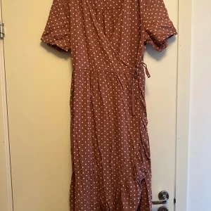 Happy Holly klänning  - Brun happy holly klänning, köpt från Vinted men säljs då den inte passar. Storlek 40/42