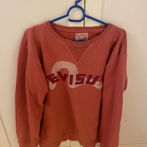 Evisu sweatshirt tjocktröja hoodie  - Någon små fläck längst ned som man knappt ser, annars bra kvalle för hur gammal den är! Färgen är koral för er som ej ser. 