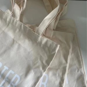 Tre totebags - Tre stycken totebags från nailster. Beigea med vitt tryck. Aldrig använda