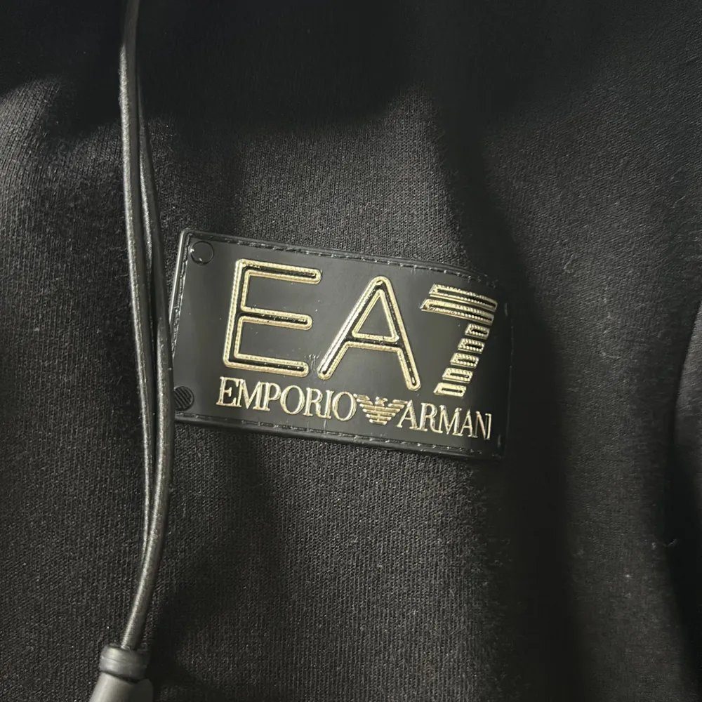 En svart zip hoodie från Emporio Armani med dragkedja och huva. Hoodien har två framfickor. Köpt i butik för 2399kr. Använd 5-6 gånger vid bra tillfällen. Storlek S/M.. Hoodies.