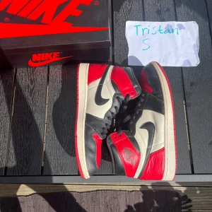 Jordan 1 High Bred Toe - Jordan 1 high Bred Toe Storlek 45.5/ us 11.5 Hål i hälarna inuti skorna som går att fixa/ lappa över.  Utöver det så är skorna i helt okej skick, bedöm själv.  All og! Hör gärna av er vid fundering om något angående skorna!