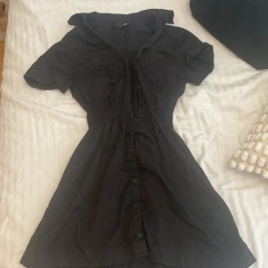 Svart klänning från H&M - En svart klänning från H&M med korta ärmar och knappar framtill. Perfekt festklänning 🥂💓😽