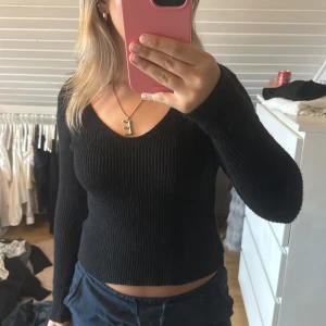 Stickad tröja - Svart stickad tröja som inte kommer till användning 