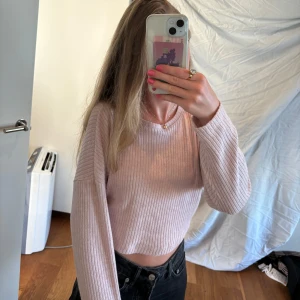 Ljusrosa ribbad tröja - En ljusrosa ribbad tröja med långa ärmar. Tröjan är croppad och har en normal passform.