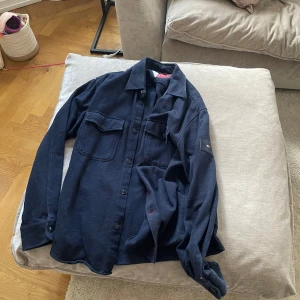 Tommy hilfiger Overshirt  - Fin Overshirt från märket Tommy Hilfiger, den är använd men i bra skick, köpt för 1400, mitt pris 500kr. Vid frågor är det bara att höra av sig pris kan även diskuteras