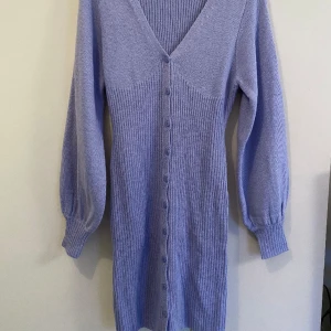 Lavendellila stickad klänning från ASOS - Lavendellila stickad klänning från ASOS, in the style. Helt ny och oanvänd, tight kort passform med ballongärmar, jätte söt 🌺 passar storlek S, men Stretchig iom att den är stickad. Nypris 439kr