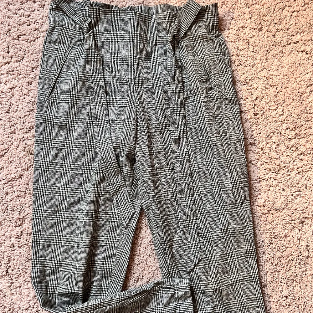 Stiliga kostymbyxor i grå rutigt! Skitsnygga till en vanilj t-shirt eller matchande kavaj.  Används inte längre för dem är för små för mig.. Jeans & Byxor.