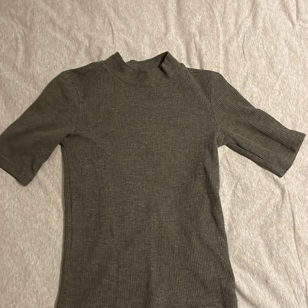 1 st grå stickad kortärmad tröja. Använd ett fåtal gånger och säljs pga att den är för liten. Skriv för fler bilder. T-shirts.