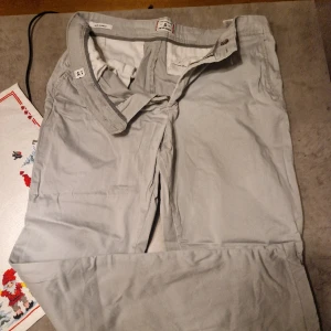 Chinos från Jack&Jones - Säljer super sköna chinos från J&J, i färgen grå, sparsamt använda, inga skador eller skavanker. Säljs pga viktnedgång. Vid frågor släng iväg ett DM.