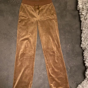 Juicy Coture byxor - Juicybyxor i fint skick säljes pga att jag har tröttnat på dem. Köptes förra året men har använts ganska lite. Alla metallbitar är kvar.💞 Finns fler bilder om man är intresserad Färgen är brun och finns ej kvar på hemsidan tror jag.💕 Dem är i stlk S
