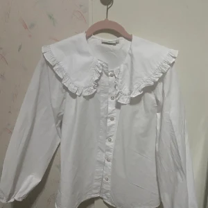 Skjorta med krås - En basic vit skjorta med gullig krås som använts max 3ggr. Är väldigt bra för layers i fits💗 st är XS men passar i S också!
