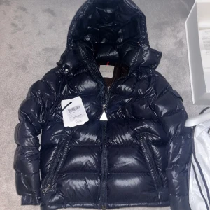 MONCLER MAYA - Säljer nu min Moncler maya jacka då jag har vuxit ur den! Den är i färgen navy, storlek 2 och 9,5/10 skick då den är sparsamt använd. Nypris idag ligger på ca 17000. Allting og medfås, galge, box, kvitto, tags, porträtt, och jackfodral. 