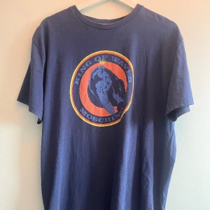 Moschino t shirt - Blå Moschino t shirt med "king of the waves" tryck. Bra skick, storlek XL