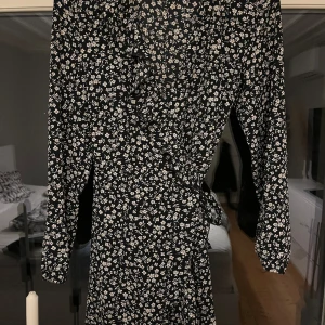 Klänning - Blommig klänning från Only. Omlottklänning med volang. Storlek 38. Långärmad.