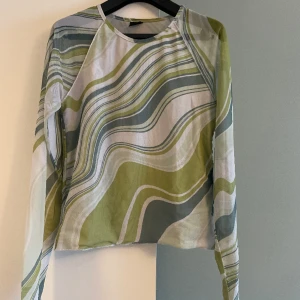 Mönstrad topp i mesh - Meshtopp i grönt mönster. Dubbelt meshtyg över kroppen så den syns inte igenom så mycket.  Storlek M. Köpt på Gina Tricot. I gott skick, använd 2ggr. 