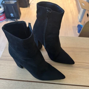 Ankelstövlar i mockaimitation - Boots med klack i svart mockaimitation i storlek 37. Använda vid ett tillfälle.   Nypris 599 kr Säljer dem för 300 kr  Hämtas på plats eller skickas mot fraktkostnad 