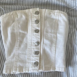 Vit jeans topp - Säljer denna jeanstoppen från pull&bear. Endast testad men var för liten (har köpt på vinted så vet ej tidigare info) har några trådar som sticker ut men vid önskemål kan jag klippa bort och tvätta innan leverans . Skriv i dm om frågor🫶🏻