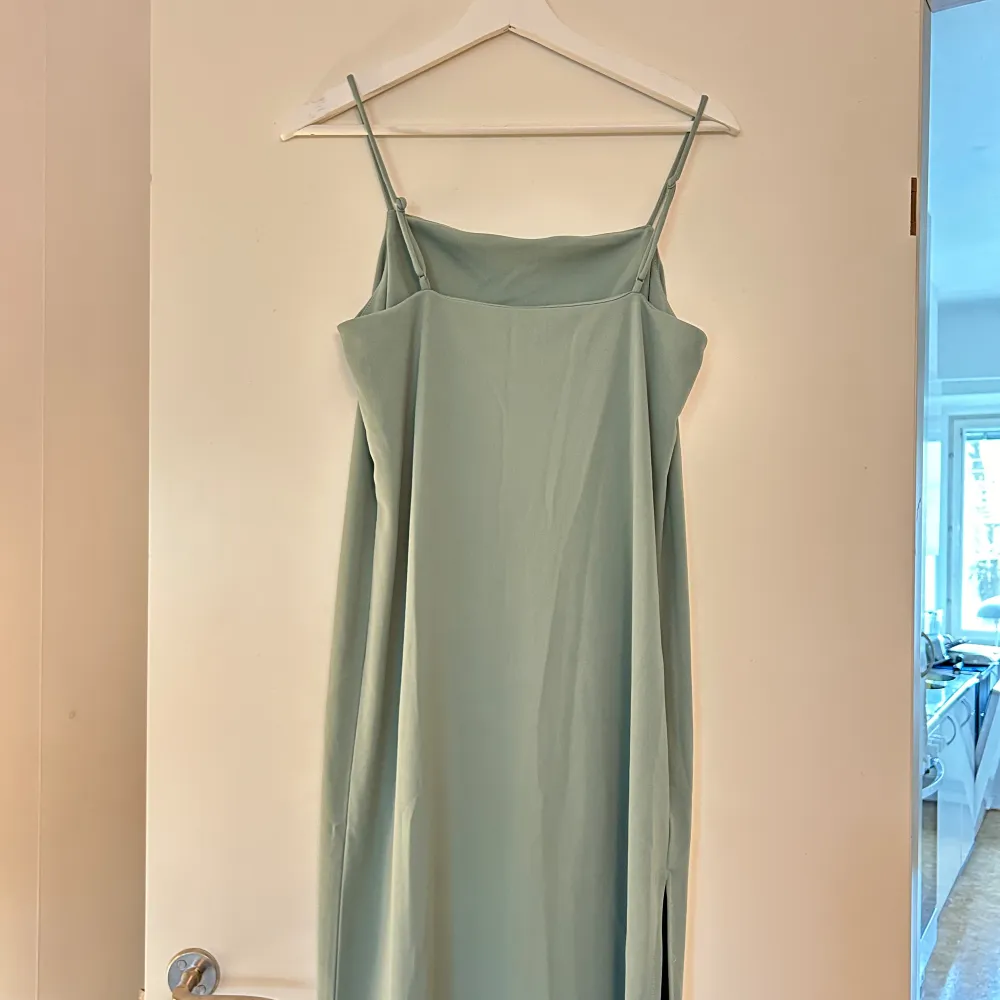 Grön klänning från H&M med slits på ena sidan! Använd fåtal gånger💕 Banden går att justera. . Klänningar.