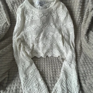 Stickad tröja med hål  - Vit stickad tröja med hål, den har utsvängda armar, i bra skick, passar S-L 