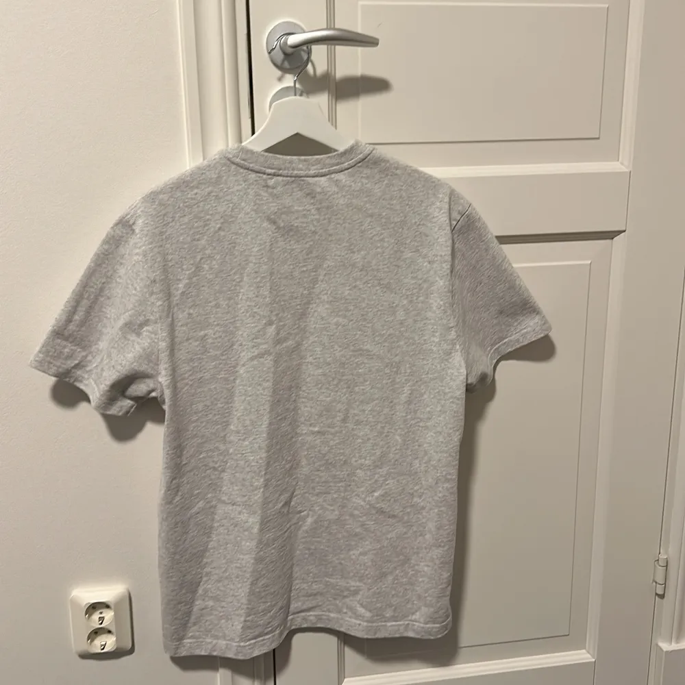 Axel arigato t-shirt i storlek M(Passar L)  Snygg tröja som har hängt i garderoben pga för stor. Tröjan är i nytt skick då den aldrig har används.. T-shirts.