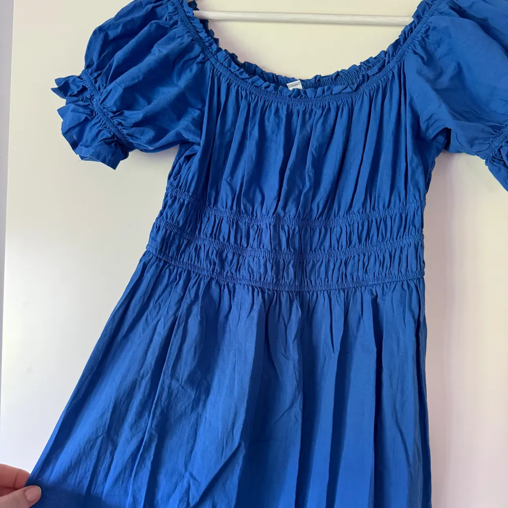 En klarblå klänning med volangen som är midi/maxi lång. Går att ha både med fyrkantig urringning eller off shoulder. Nästan aldrig använd, jättefint skick. . Klänningar.