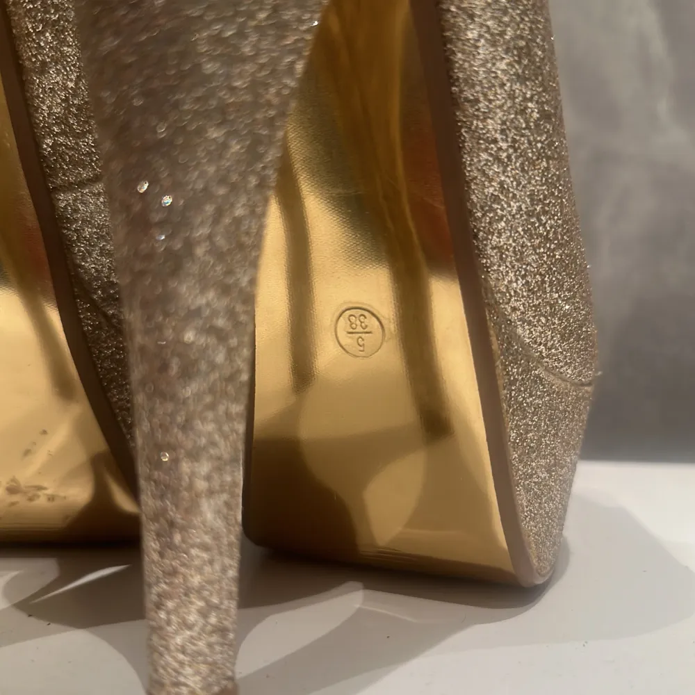 Guld-glittriga stilettklackar med öppen tå, i storlek 37/38🌟  Dessa är i god kvalitet. Knappt använda. De har mest stått på hyllan utan användning. Skriv om mer information🌟. Skor.