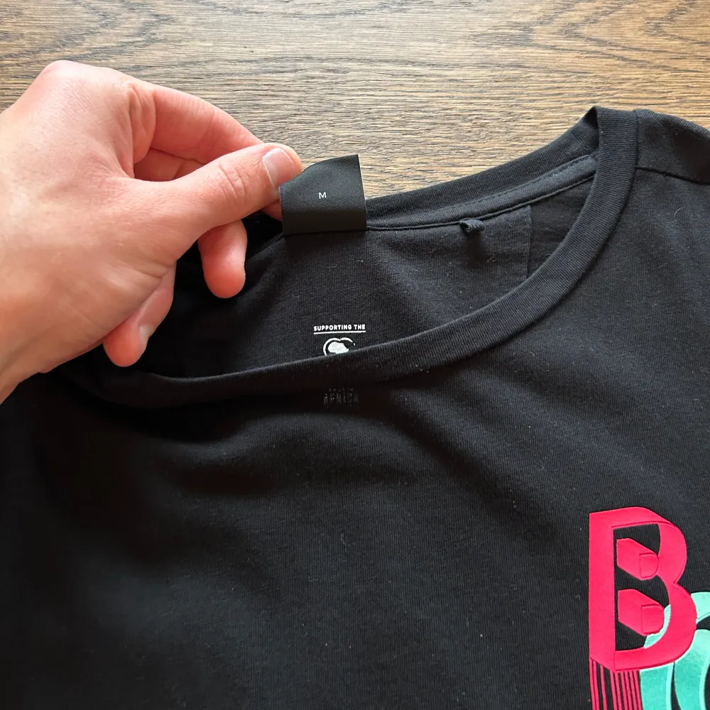 En svart Hugo boss t-shirt med färglatt motiv, som ger en ”3D-känsla”. Tröjan är sparsamt använd och i väldigt fin skick. Storlek Medium.. T-shirts.