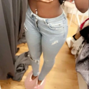 Ljusblåa jeans - Fina ljusblåa jeans som är midwaist med hål.