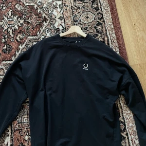 Fredperry - raf Simons colab  - Säljer den här riktigt snygga long sleeven. Samarbete mellan fred Perry och raf Simons. I väldigt fint skick den är knappt använd. Hojta om du har frågor!