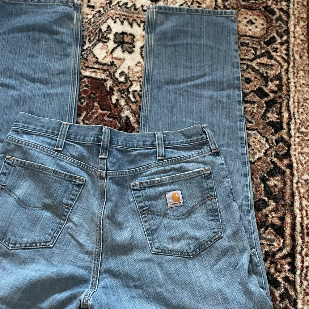 Säljer dessa svin snygga carhartt jeans med distressing i relaxed fit. Köpt vintage och i gott skick!. Jeans & Byxor.