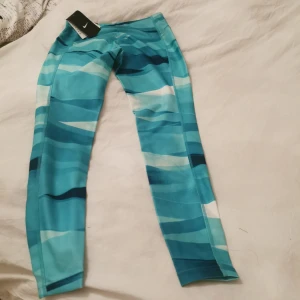 Tränings tights i märket Nike  - Turkosa tränings tights i märket Nike drifit Storl S Katt finns i hemmet 