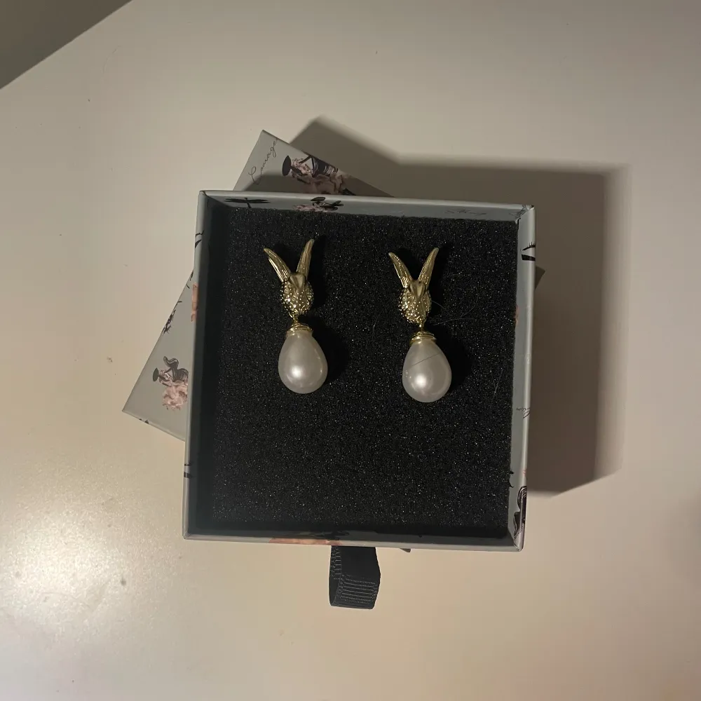 Ett par hare chic earrings från ioakus limited edition påskkollektion. Örhängena är guldiga och endast använda en gång. Säljes endast för att jag behöver pengarna. Pärlan går att ta av 🙏. Nypris är 499.  Lådan på bilden medföljes inte. 💘💘💘. Accessoarer.