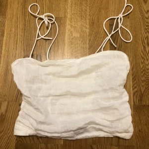 Linne topp - Vit Croptop i linnematerial med tunna knytaxelband. Pris kan diskuteras:)