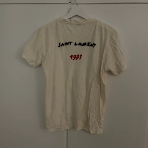 Yves saint laurent t shirt - Säljer denna snygga ysl t-shirten som är storlek S men rätt så liten i storleken. Den är lite skrynklig men syns mindre när man har på den men annars perfekt skick och äkta! Den är rätt så tunn så är dunder till sommarn! Skriv gärna vid funderingar!